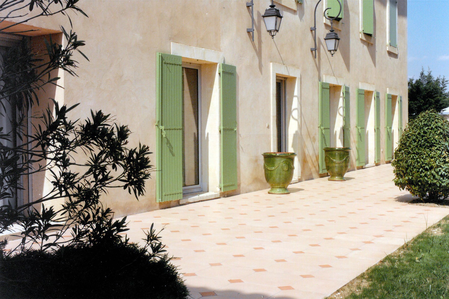 Grande terrasse en dalle sablée avec cabochon rose.