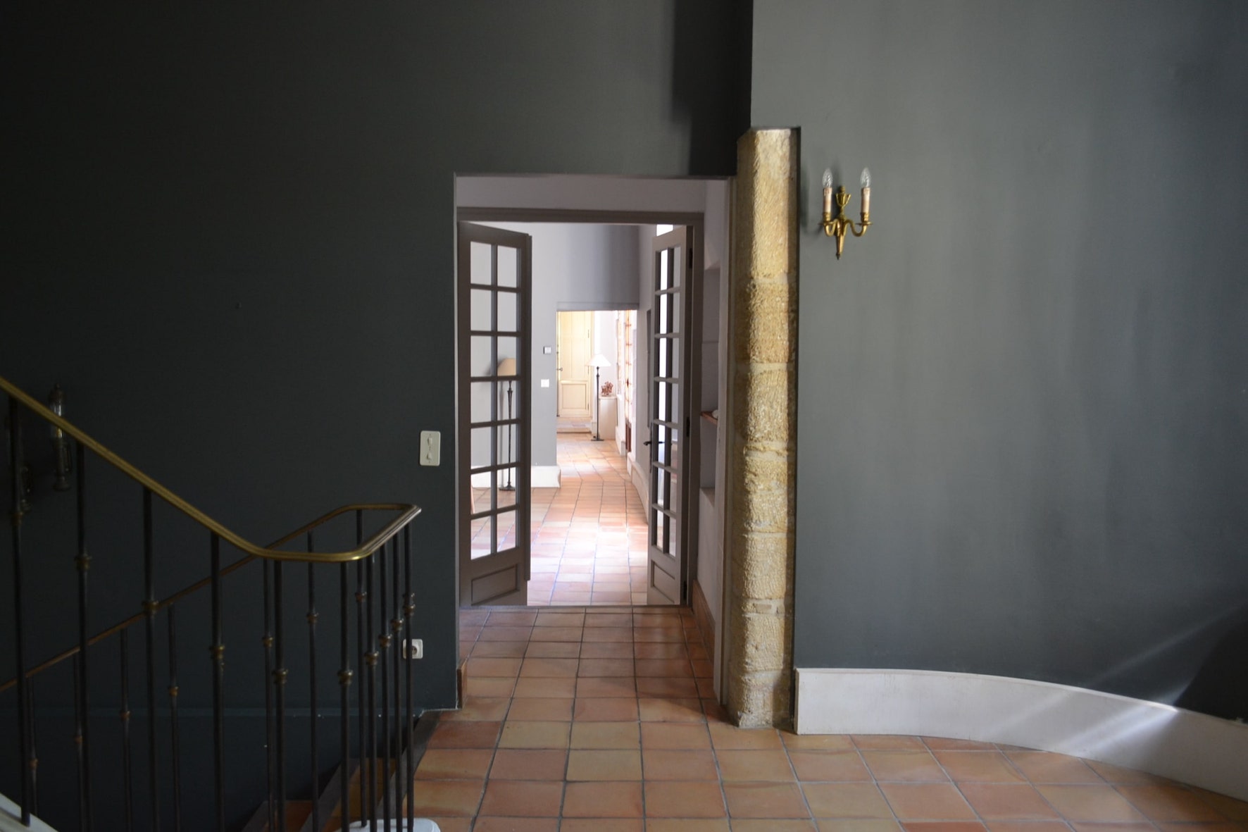 Porte intérieure petits carreaux donnant sur couloir en terre cuite.